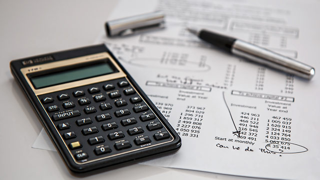 Calculator sitting next to financial paperwork.