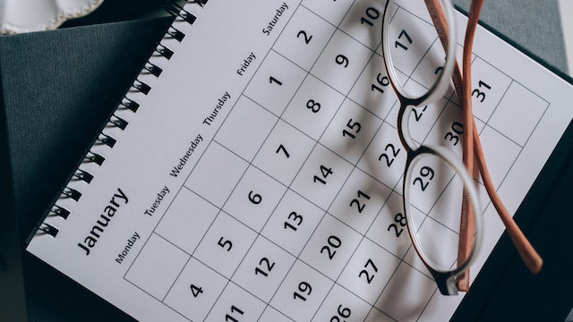 Calendar with a pair of glasses sitting on top.